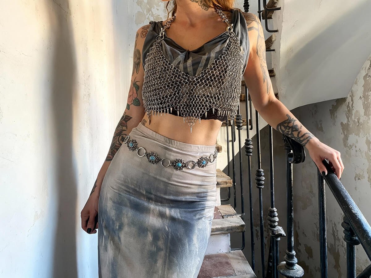 Mujer en escaleras con cinturón y malla de acero